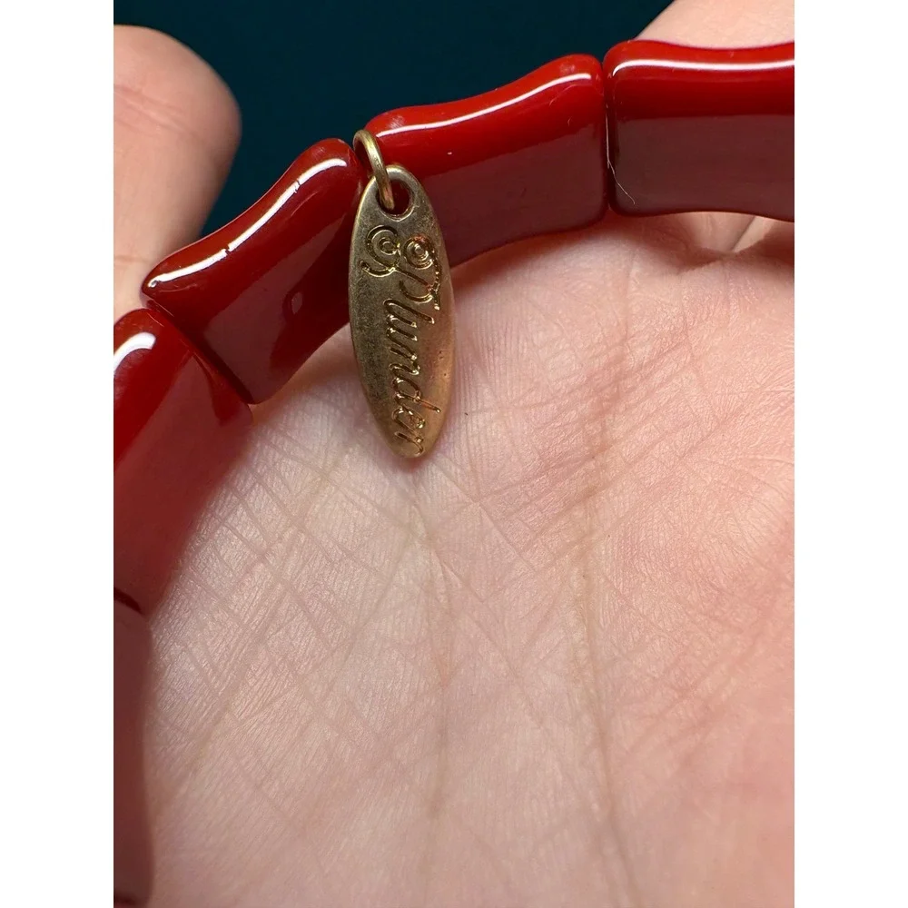 Plunder Design Red Bamboo Style Stretch Bracelet Gold Tone Logo Charm